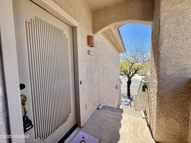 doorway to property with stucco siding and a balcony