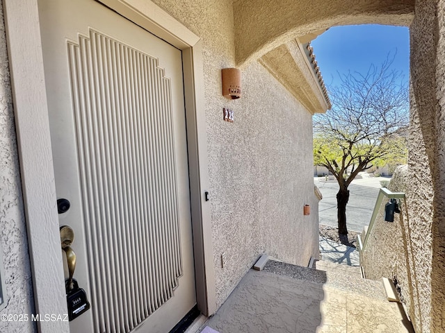 property entrance with stucco siding