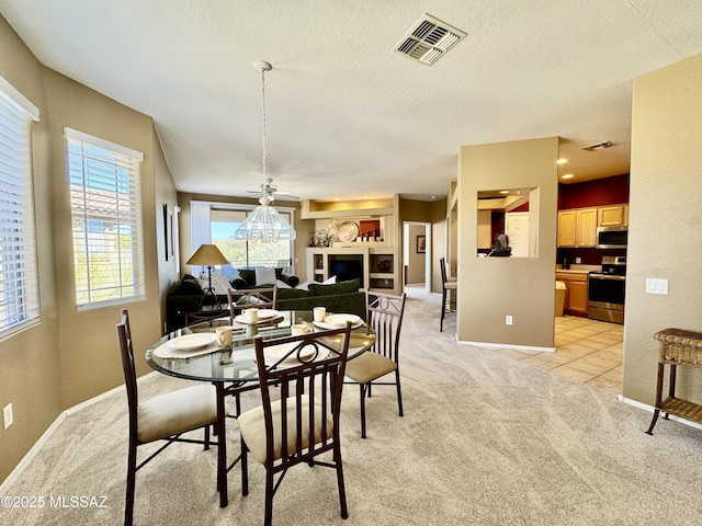 dining area with visible vents, light colored carpet, a textured ceiling, and baseboards