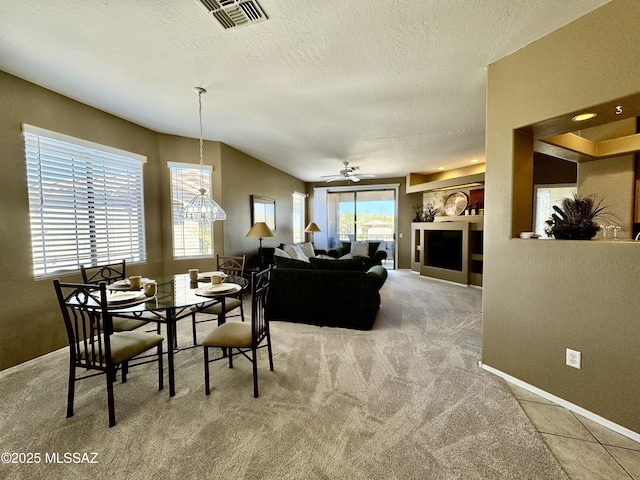 dining space with visible vents, baseboards, ceiling fan, carpet flooring, and a textured ceiling