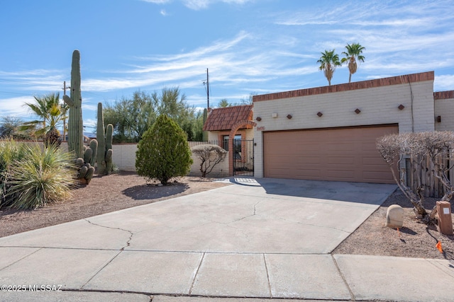 view of front of house featuring driveway, an attached garage, a gate, and fence