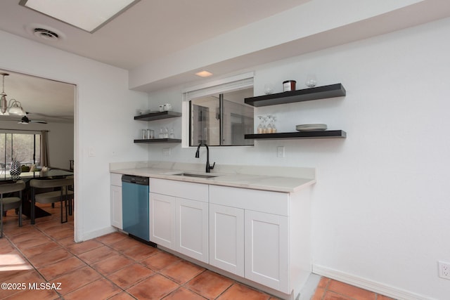 kitchen featuring a sink, white cabinetry, light countertops, stainless steel dishwasher, and open shelves