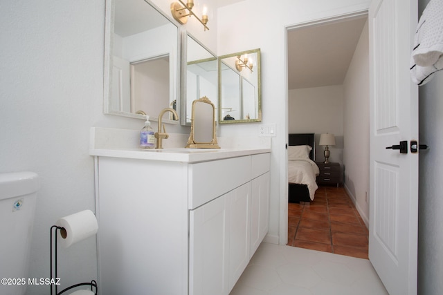 bathroom with vanity, toilet, and ensuite bathroom