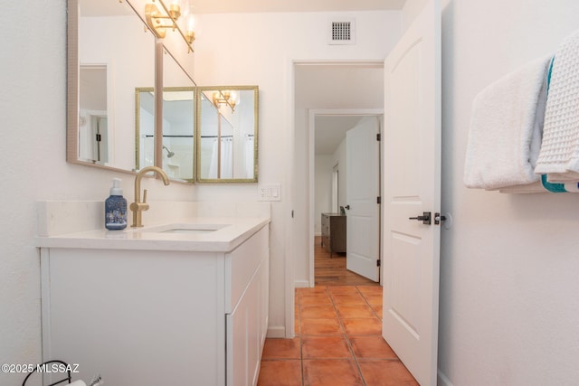 bathroom with baseboards, vanity, visible vents, and tile patterned floors