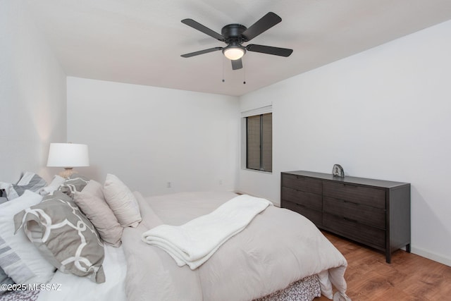 bedroom with wood finished floors, a ceiling fan, and baseboards