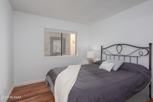 bedroom featuring dark wood-style flooring and baseboards