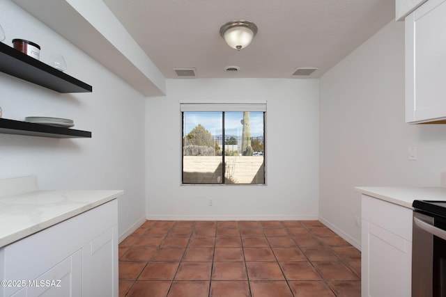 kitchen with open shelves, stove, visible vents, and white cabinets