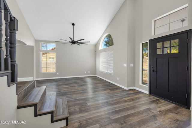 entrance foyer with high vaulted ceiling, dark wood-type flooring, a ceiling fan, baseboards, and stairway