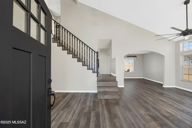 foyer featuring dark wood-type flooring, stairway, a ceiling fan, and baseboards