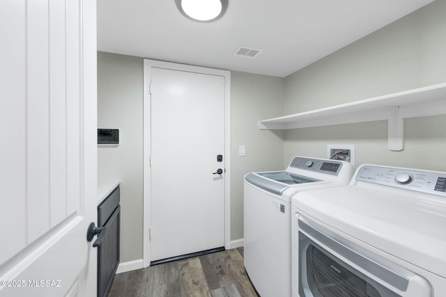 clothes washing area with laundry area, visible vents, dark wood finished floors, baseboards, and washing machine and dryer