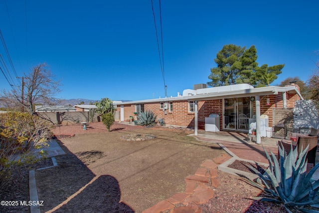 rear view of house featuring brick siding and a patio