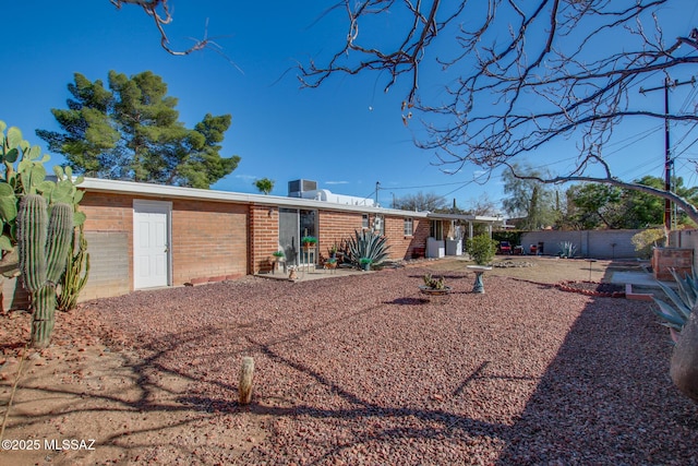 view of front of home with brick siding and fence