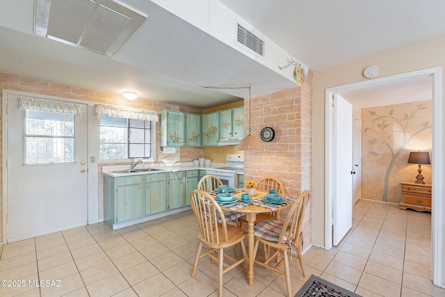 kitchen with light countertops, visible vents, a sink, and electric range