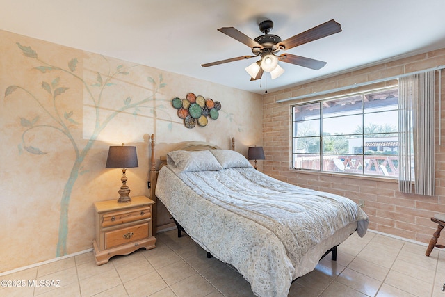 bedroom with light tile patterned floors, brick wall, and a ceiling fan