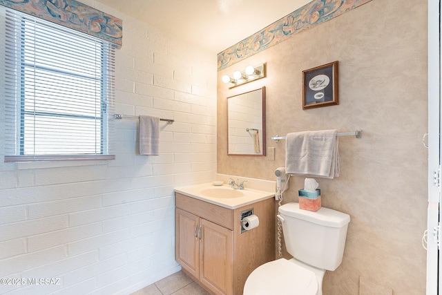 half bathroom with tile patterned flooring, vanity, and toilet