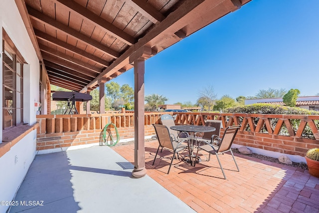 view of patio featuring outdoor dining area and fence