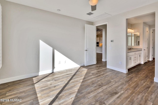 30776 S Sand Hurst Ln, Oracle, AZ 85623 - unfurnished bedroom featuring dark wood finished floors, baseboards, ensuite bathroom, and a ceiling fan