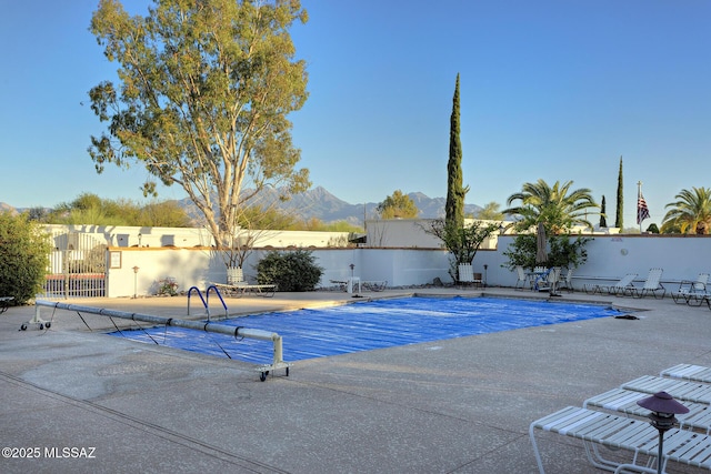 view of pool with a patio, fence, a mountain view, and a fenced in pool