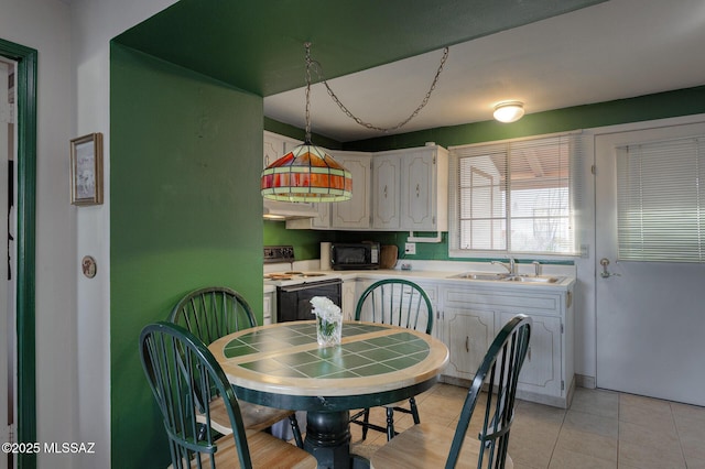 kitchen featuring white electric stove, light countertops, white cabinetry, black microwave, and a sink