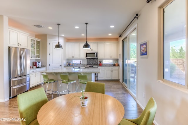 dining room with recessed lighting, visible vents, light wood finished floors, and baseboards