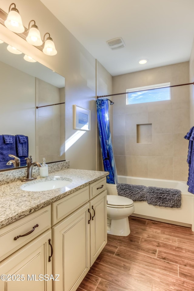 full bathroom with visible vents, wood tiled floor, toilet, vanity, and shower / bathtub combination with curtain