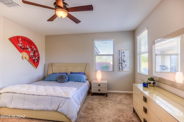 bedroom featuring light carpet, visible vents, baseboards, and a ceiling fan