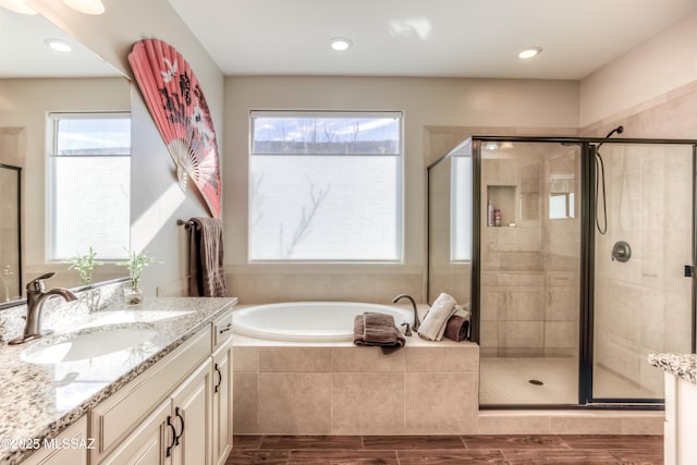 bathroom with vanity, a garden tub, and a stall shower