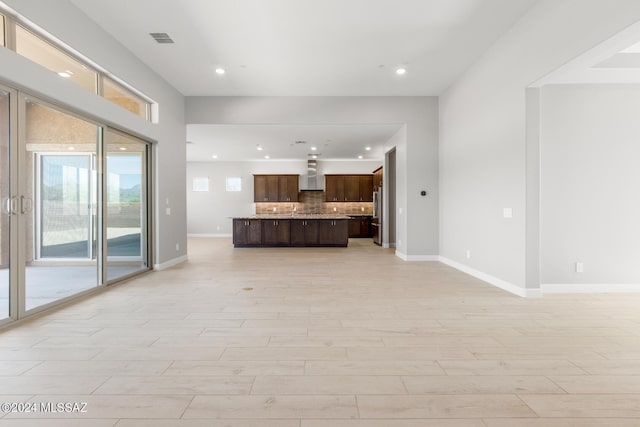 unfurnished living room with light wood-style floors, baseboards, visible vents, and recessed lighting