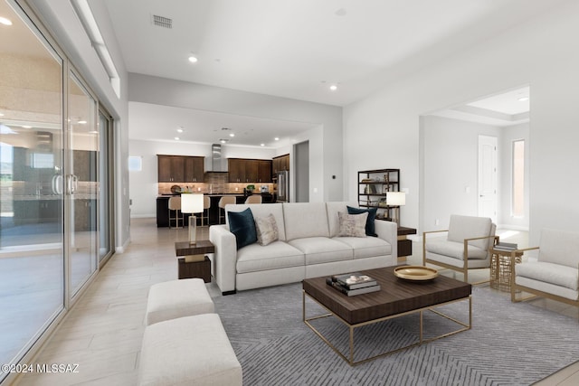 living room featuring recessed lighting, baseboards, visible vents, and light wood finished floors