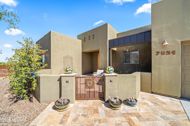 adobe home featuring a patio area and stucco siding