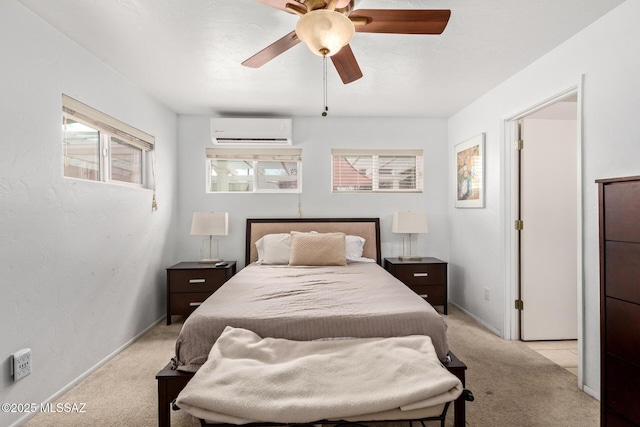 bedroom with a wall unit AC, ceiling fan, light carpet, and baseboards