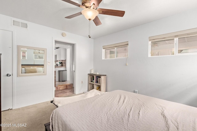 carpeted bedroom with a ceiling fan, visible vents, and multiple windows