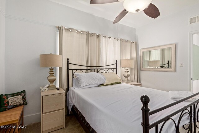 carpeted bedroom with ceiling fan and visible vents