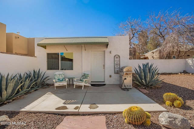 exterior space featuring a patio area, fence, and stucco siding