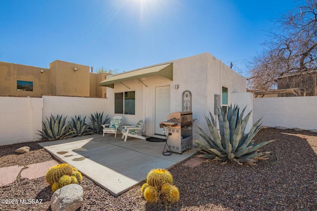 rear view of property with a patio area, a fenced backyard, and stucco siding