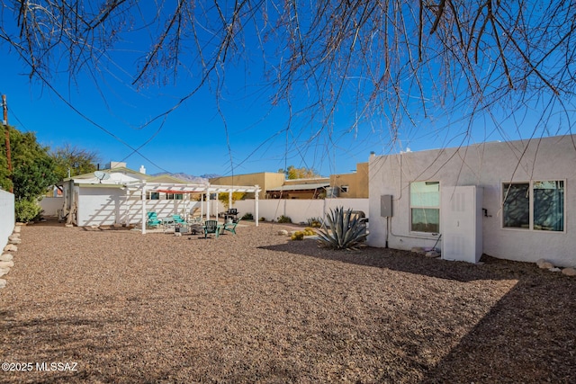 exterior space featuring a pergola, a fenced backyard, and stucco siding