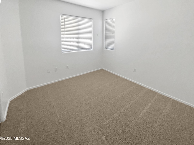 carpeted empty room with baseboards