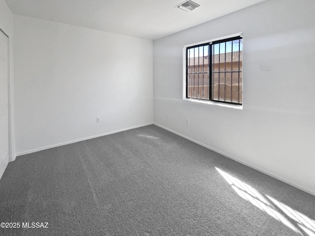 carpeted empty room featuring visible vents and baseboards