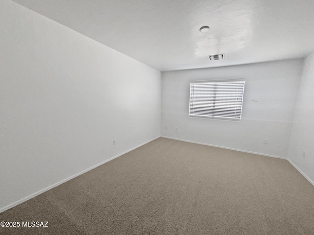 unfurnished room featuring baseboards, visible vents, and carpet flooring