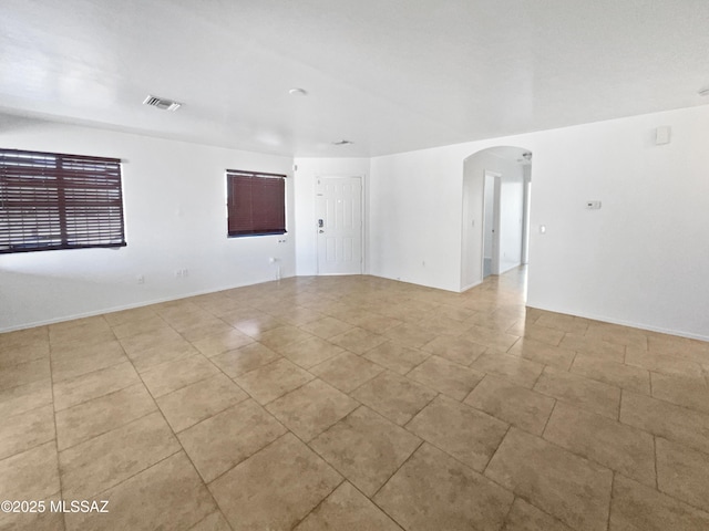 spare room with visible vents and arched walkways