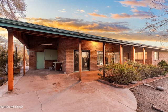 view of front facade featuring a patio and brick siding