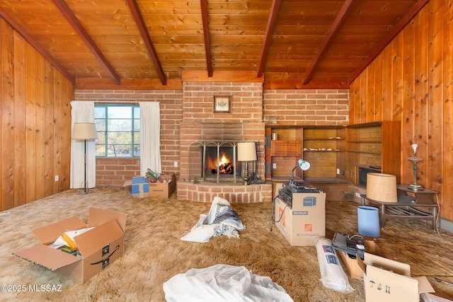 carpeted living room with wood walls, beamed ceiling, and wooden ceiling