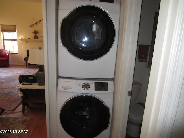 laundry room featuring stacked washer / drying machine, laundry area, and tile patterned floors