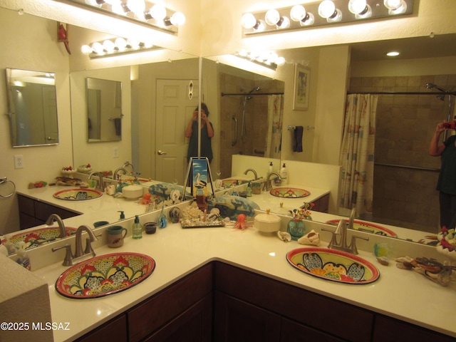 full bathroom featuring a tile shower and a sink