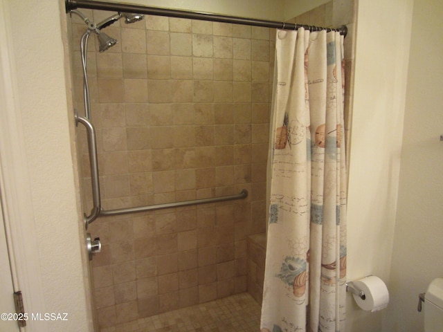 full bath featuring tiled shower and toilet