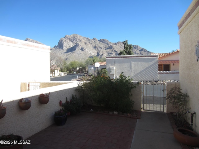 view of patio / terrace featuring a gate, fence, and a mountain view