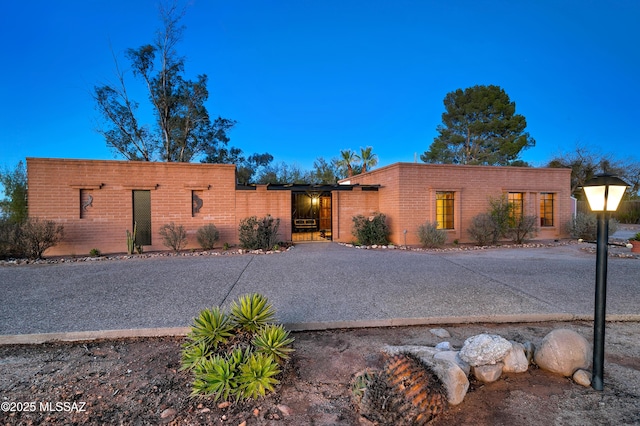 adobe home featuring brick siding