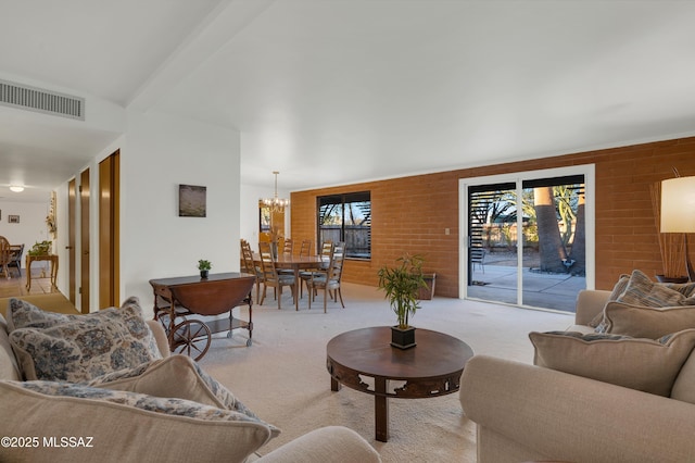 carpeted living area with an inviting chandelier, visible vents, and beam ceiling