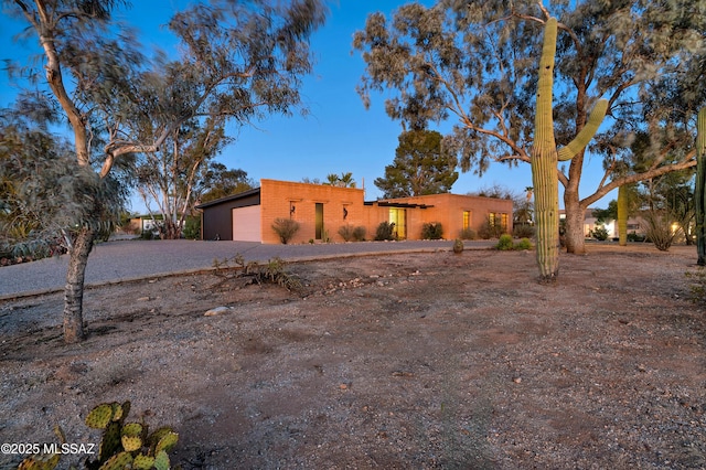 pueblo revival-style home featuring a garage and driveway