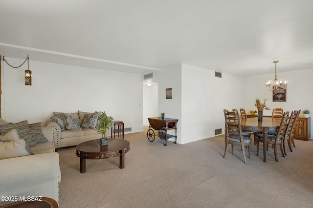 carpeted living area featuring visible vents and an inviting chandelier